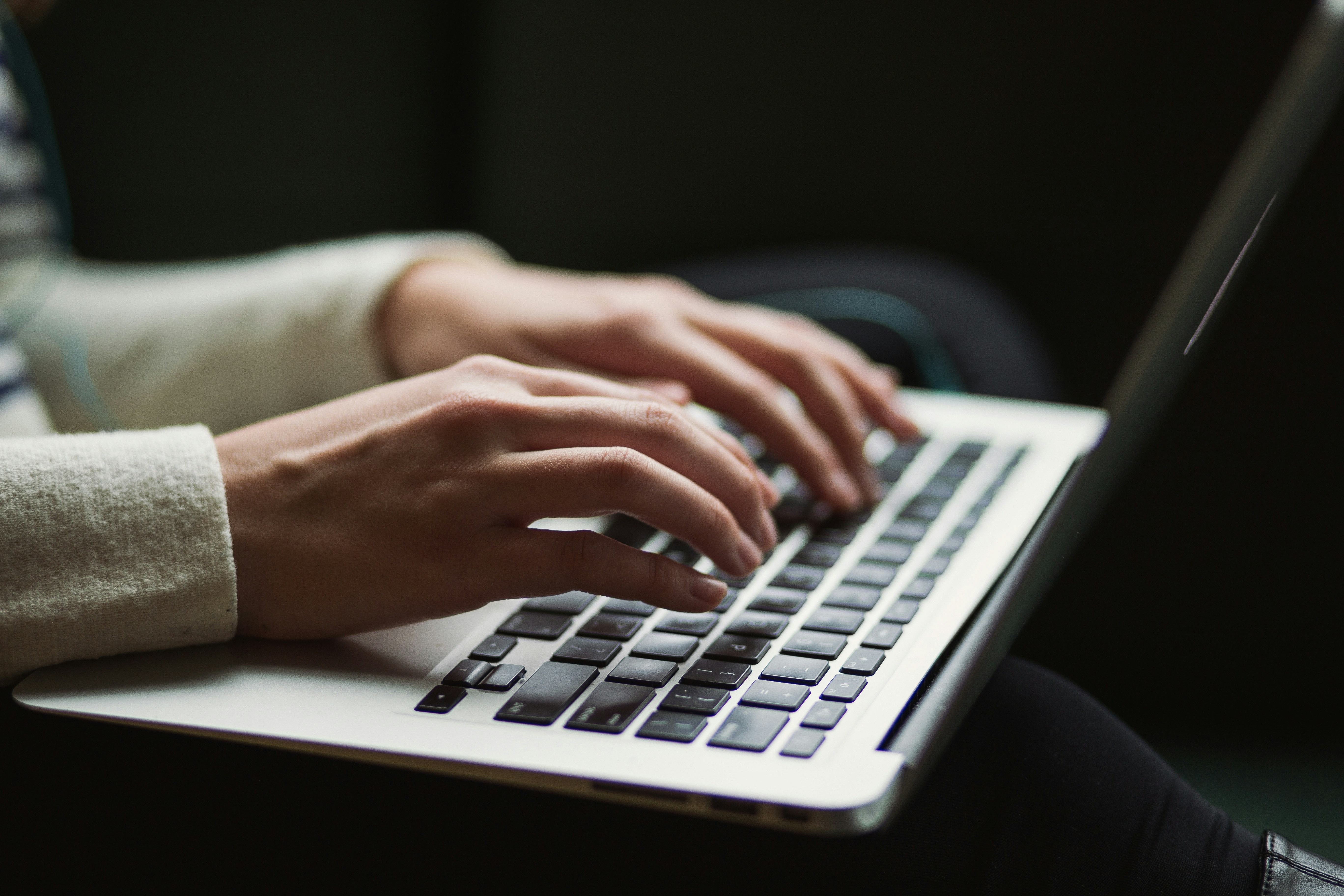 Close up of hands typing on a laptop keyboard