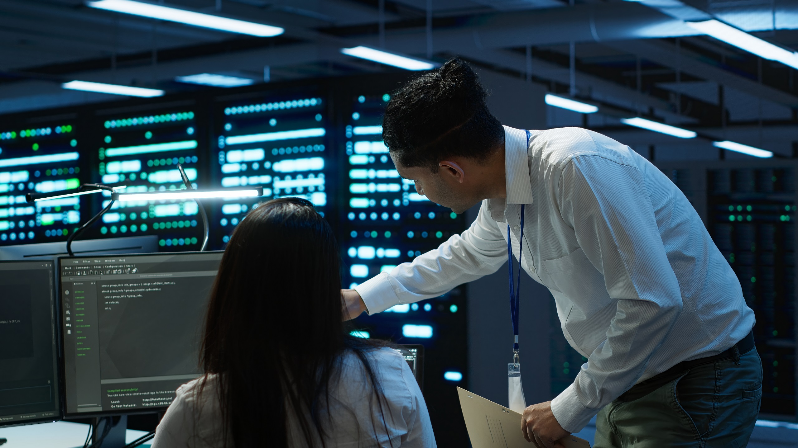 IT professionals monitoring enterprise server systems in a control room.