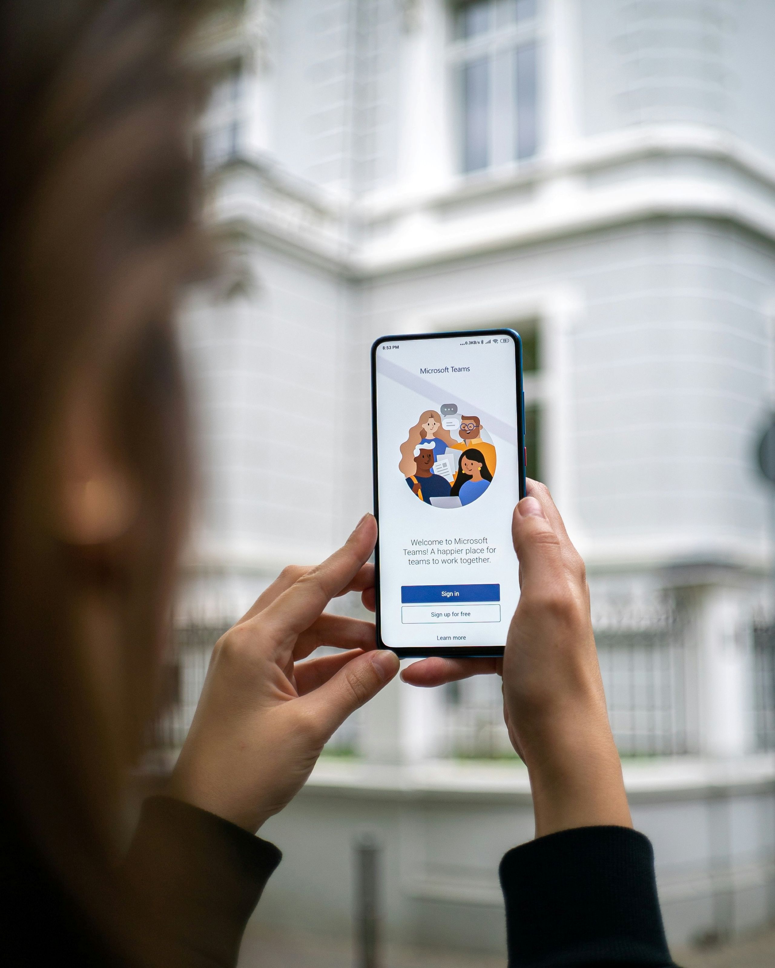 Person holding up phone showing Microsoft Teams landing page.